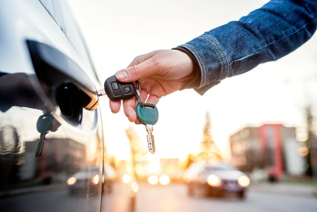 Male unlocking car door with keys