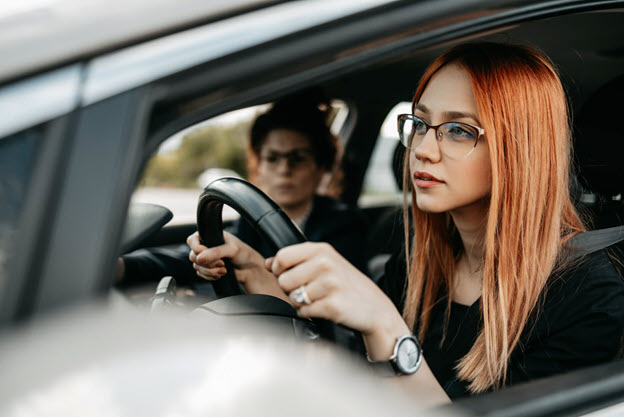 Young lady leaning on car window.