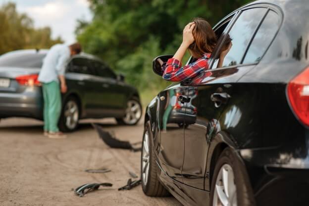 Male and female drivers after a car accident on the road