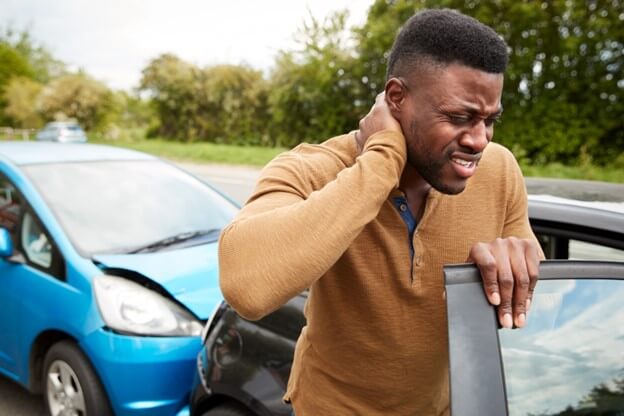 Male motorist getting out of the car after an accident. 